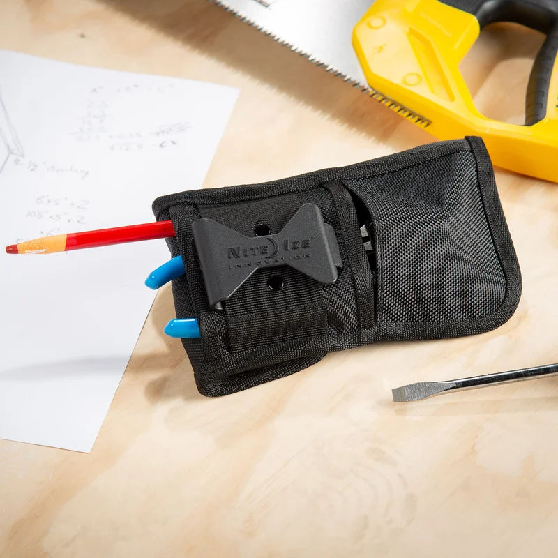 Nite Ize Clip Pock-Its XL Utility Holster in black nylon with attached clip, holding a red tool with blue handle on a wooden workbench.
