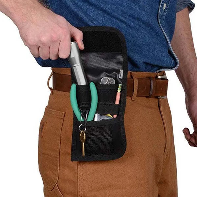 HOLSTERS - CLIP POCK-ITS XL - UTILITY black multi-pocket holster clipped to a brown belt on tan work pants, holding teal-handled pliers, key ring, silver flashlight, glasses, and pens.