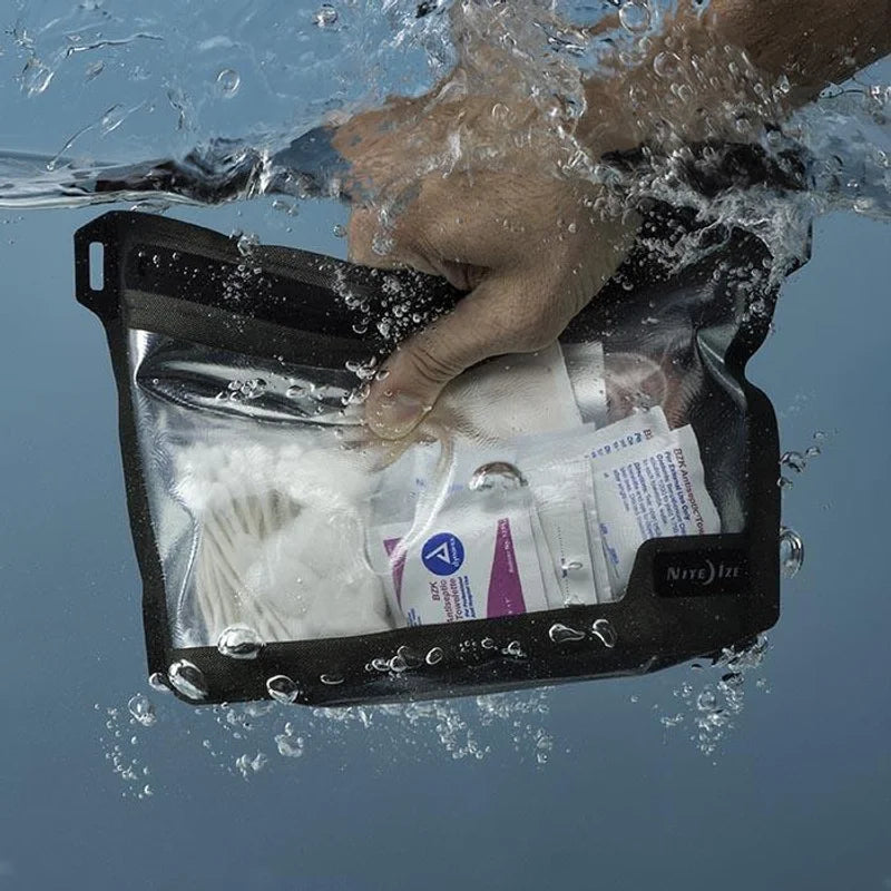 Nite Ize Waterproof Pouch with black trim and clear window held underwater, surrounded by bubbles, showing medical gauze and antiseptic towelettes inside